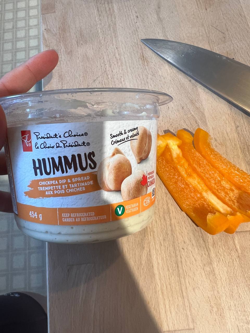 hummus container and sliced orange bell pepper