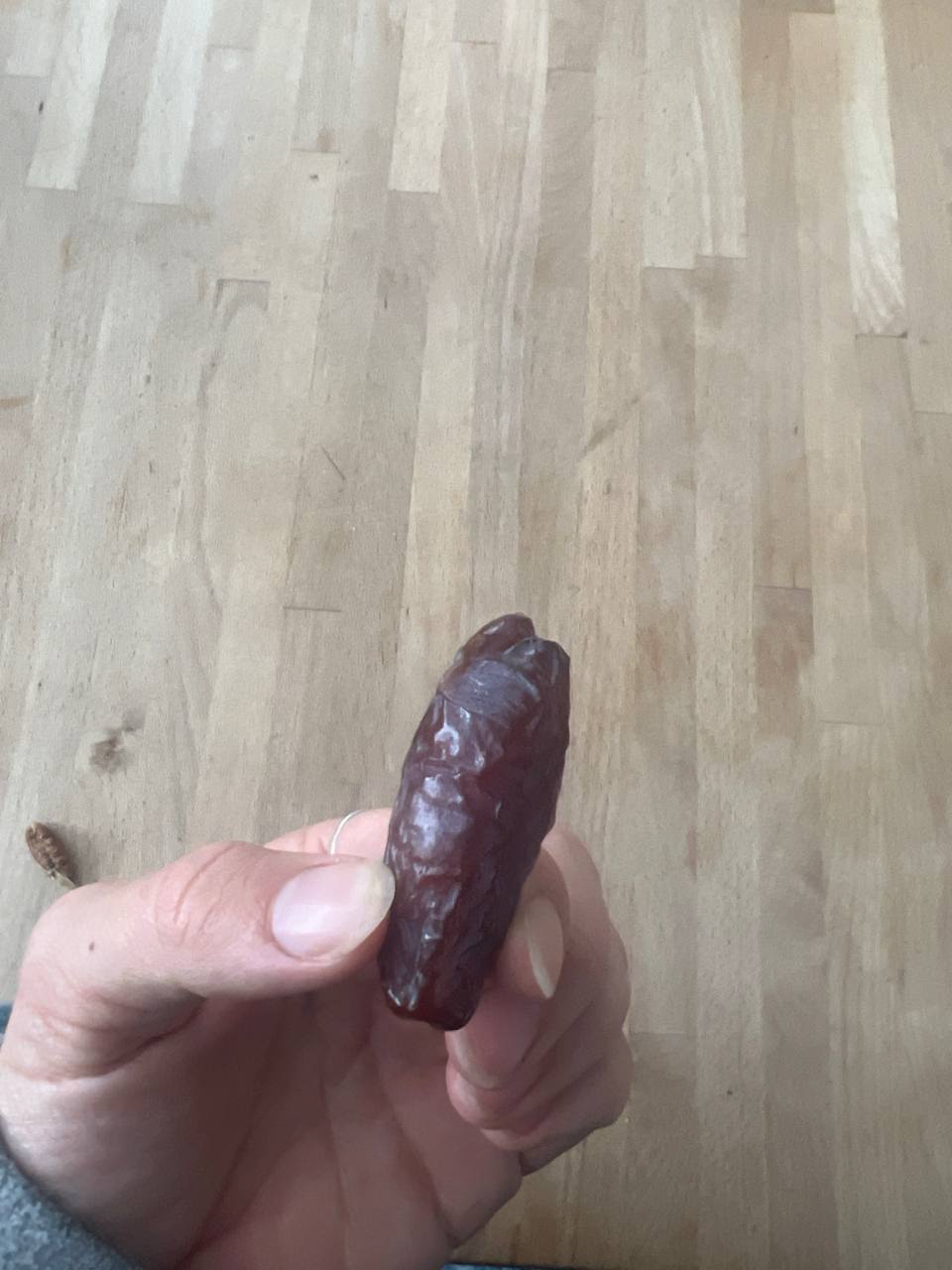 one large date held in hand