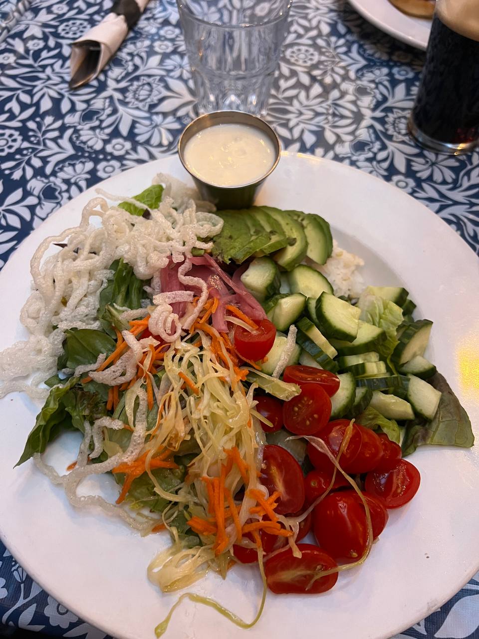 rice bowl with mixed vegetables, avocado, crispy rice noodles, and vegan sauce