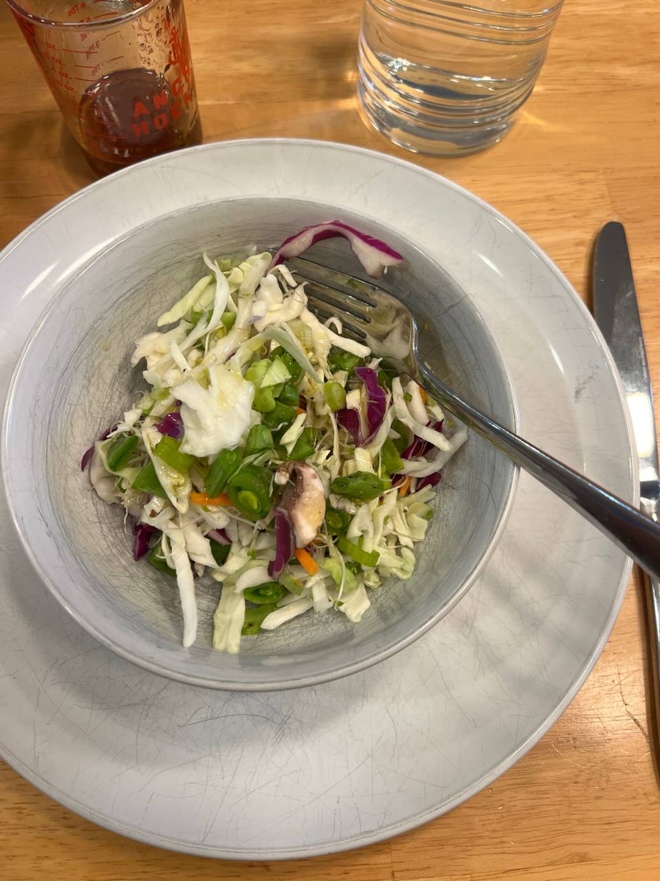 small bowl of shredded cabbage slaw with green onion, red cabbage, mushrooms, and light dressing or vinaigrette