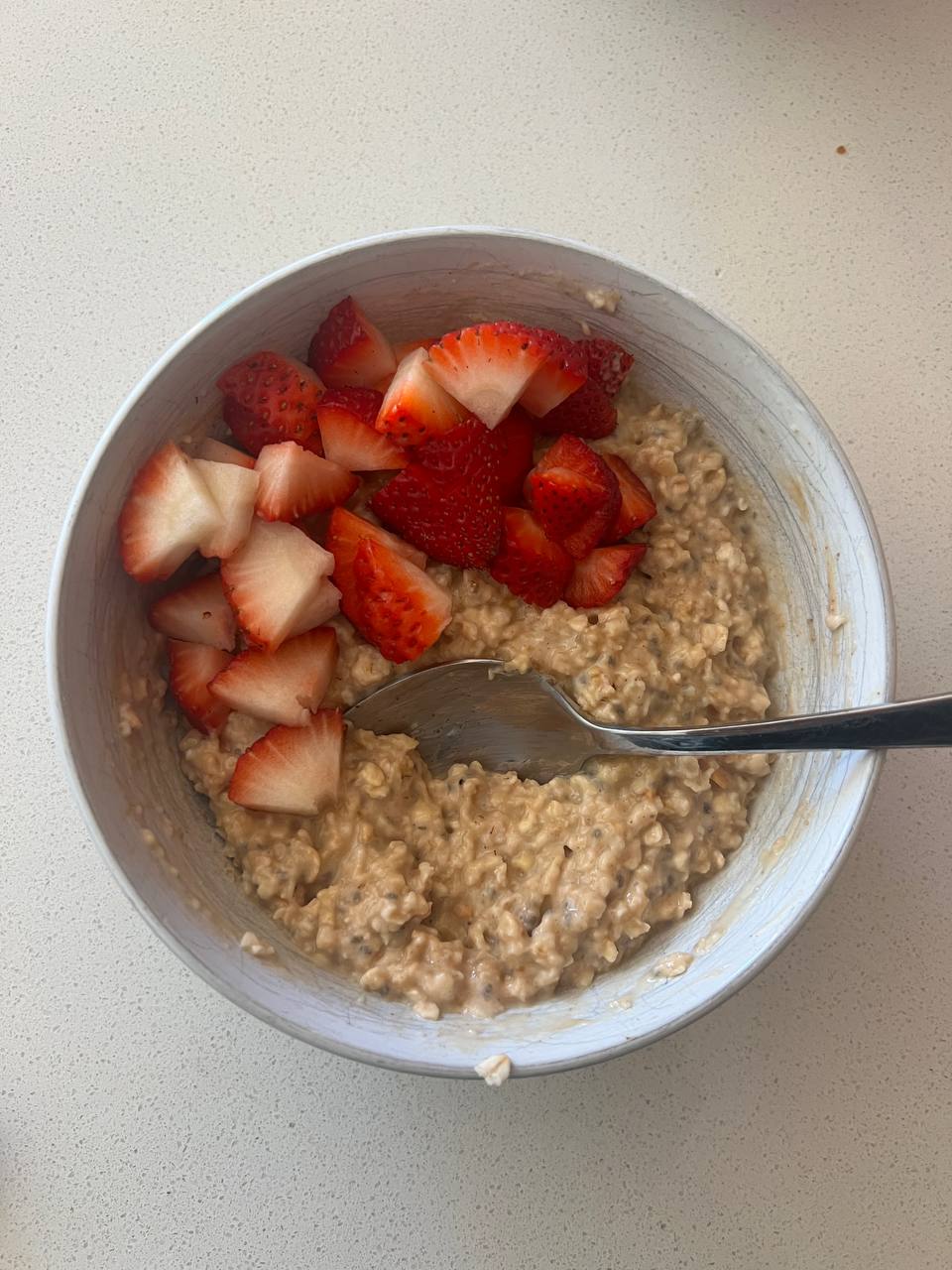 oatmeal bowl with athlete-stated ingredients of 120 mL uncooked oats, 1 tsp chia seeds, 1.5 tbsp peanut butter, 1 tsp brown sugar, and 3 strawberries