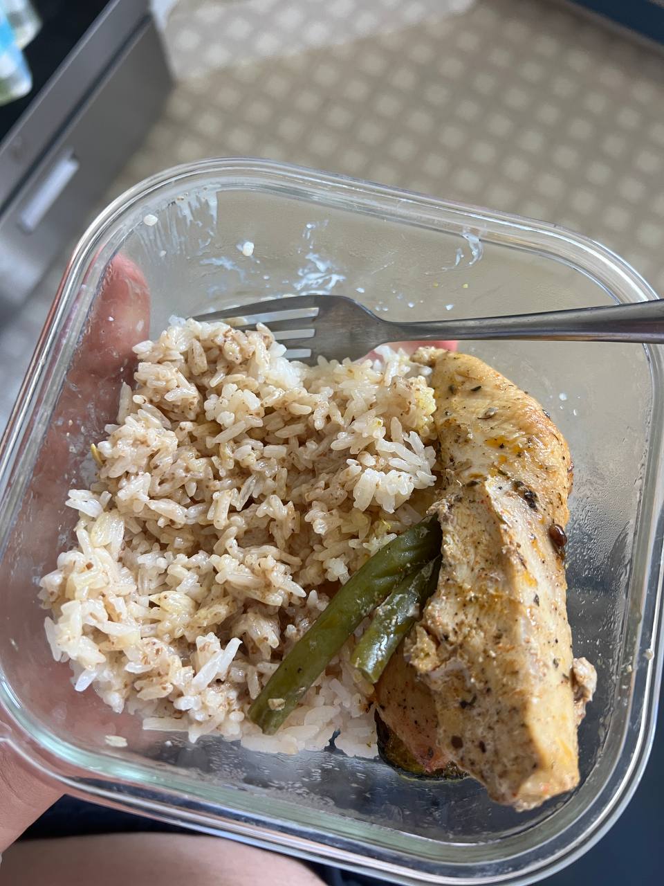 Grilled/baked seasoned chicken breast (half), Cooked white rice (seasoned/mixed with spices or onion), Green beans (2 pieces)