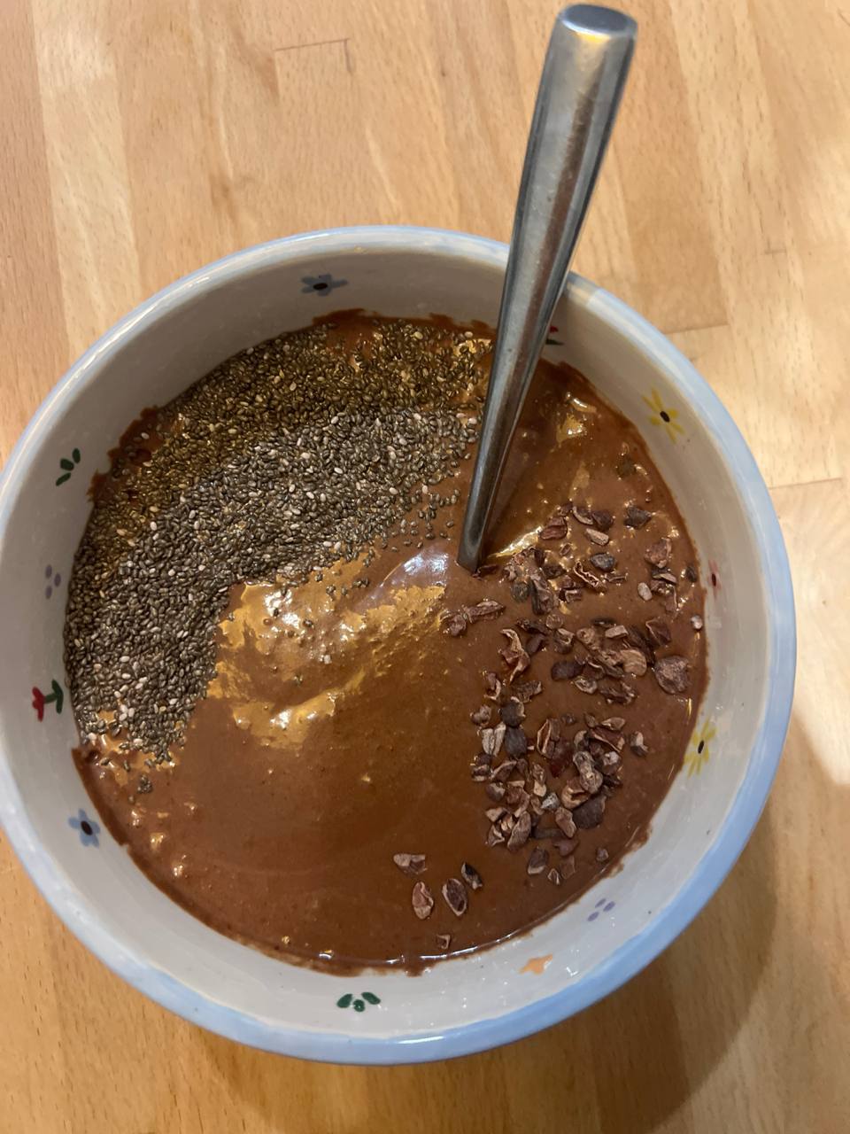 Banana (blended into base), Water (blended into base), Peanut butter (blended into base), Cacao powder (blended into base), Medjool or soft dates (blended into base), Chia seeds (topping), Cacao nibs (topping)