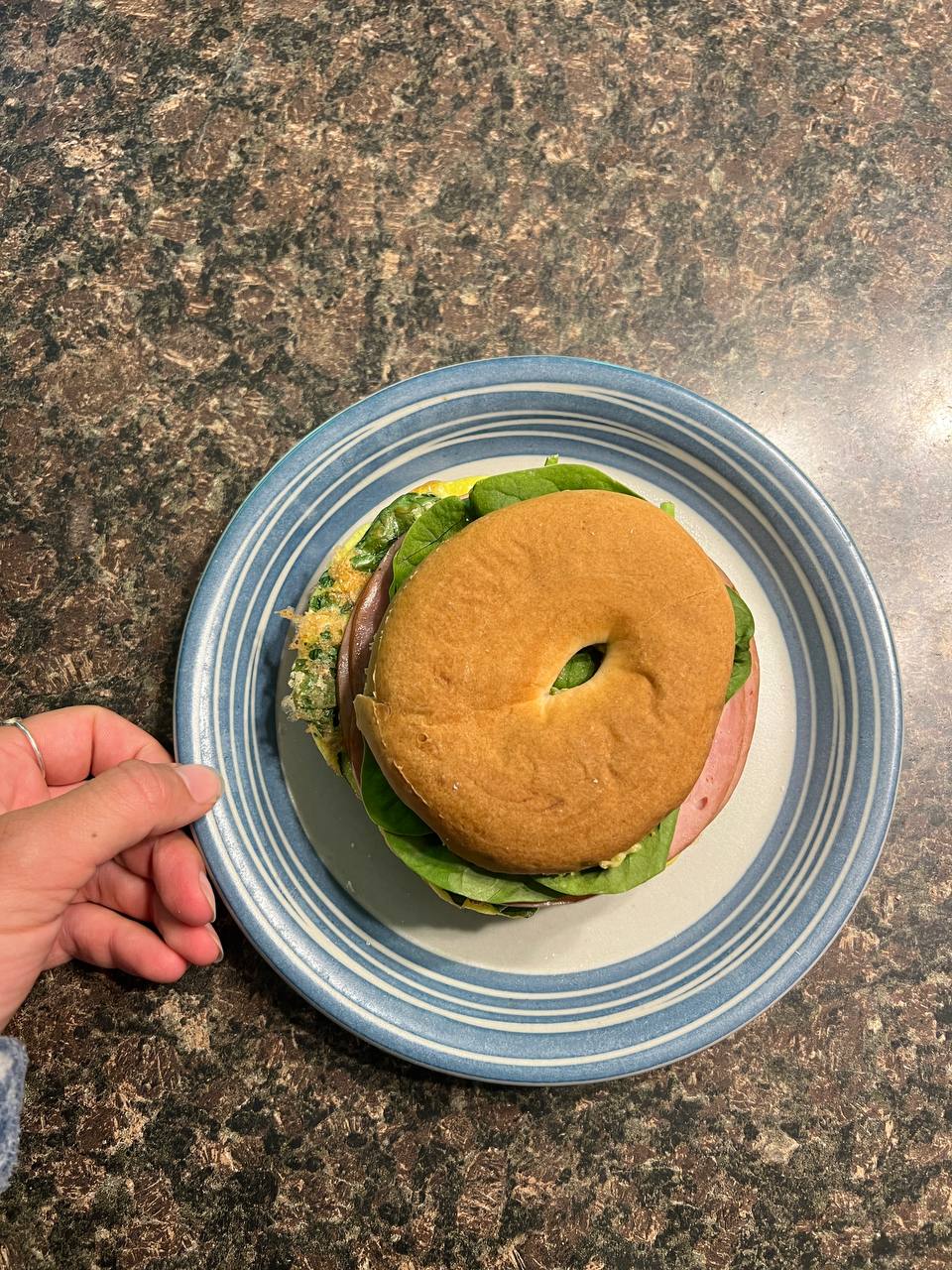 Bagel sandwich with egg, spinach, ham, and avocado