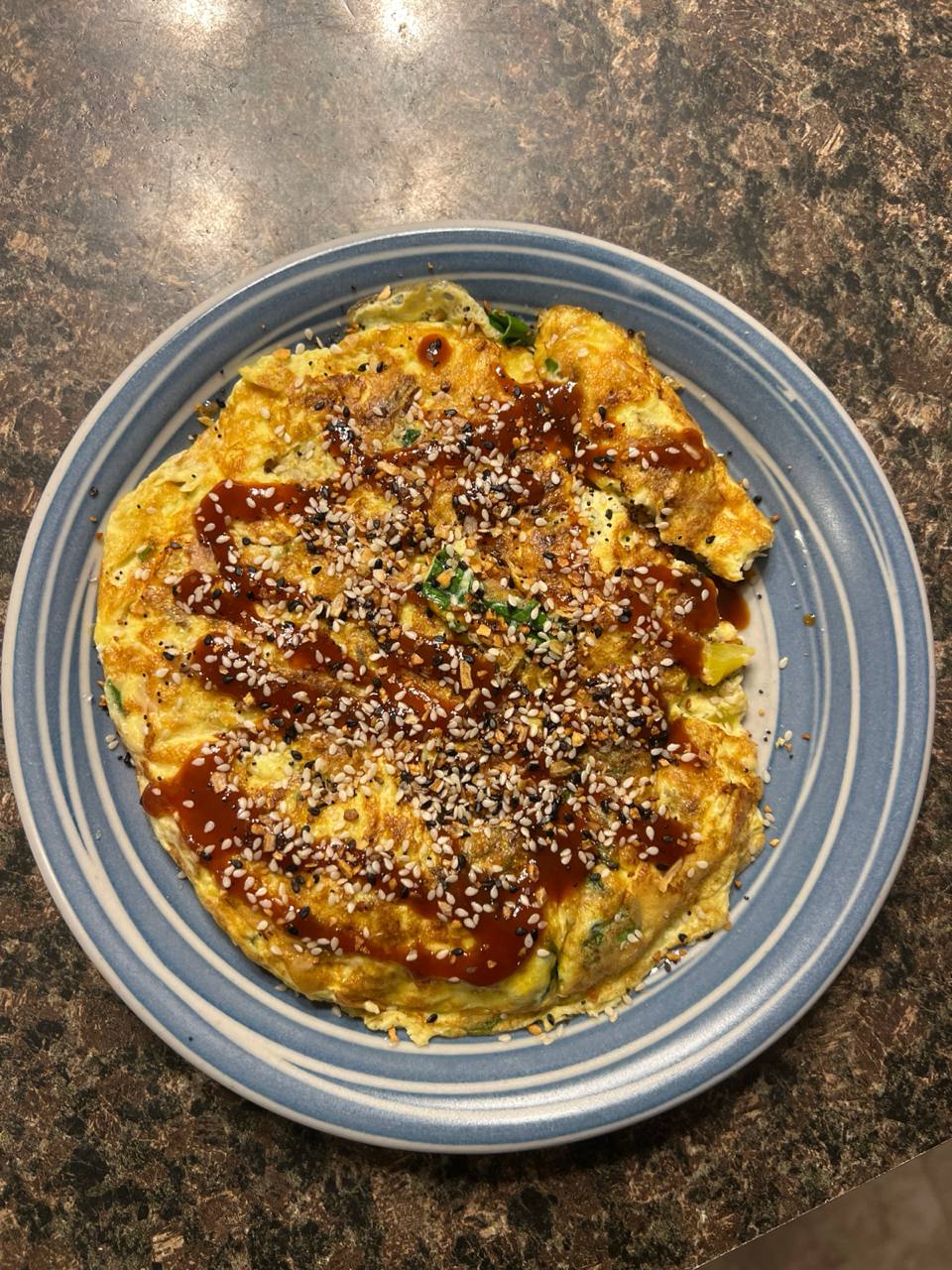 Egg and vegetable omelette or scramble with barbecue sauce and sesame seeds